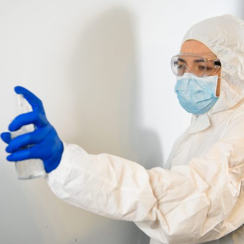 a doctor in a protective suit disinfects with an antiseptic. Coronavirus control concept. Quarantine.